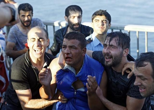 A soldier beaten by the mob (centre) is protected by plain-clothed policemen after troops involved in the coup surrendered on the Bosphorus Bridge in Istanbul. (Reuters) A soldier beaten by the mob (centre) is protected by plain-clothed policemen after troops involved in the coup surrendered on the Bosphorus Bridge in Istanbul. (Reuters)