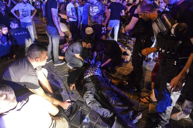 People attend to a man that was protesting against the coup, laying wounded when Turkish forces soldiers opened fire to disperse the crowd, in Istanbul's Taksim square. (AP) People attend to a man that was protesting against the coup, laying wounded when Turkish forces soldiers opened fire to disperse the crowd, in Istanbul's Taksim square. (AP)