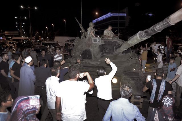 People stop a tank at Ataturk airport in Istanbul, early Saturday. (AP Photo)