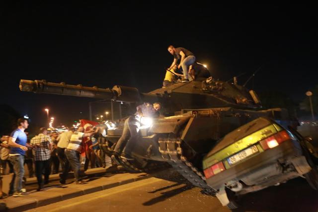 A tank crashes a car as people take streets in Ankara, Turkey during a protest against military coup. (AFP Photo)