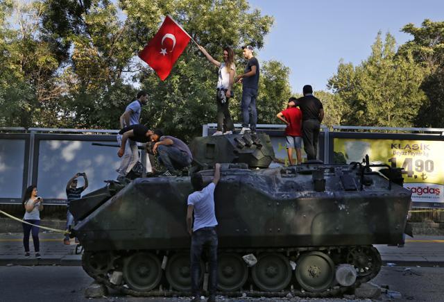 Turkish citizens stand on a damaged Turkish military APC that was attacked by protesters in a street near the Turkish military headquarters in Ankara, Turkey. (AP) Turkish citizens stand on a damaged Turkish military APC that was attacked by protesters in a street near the Turkish military headquarters in Ankara, Turkey. (AP)