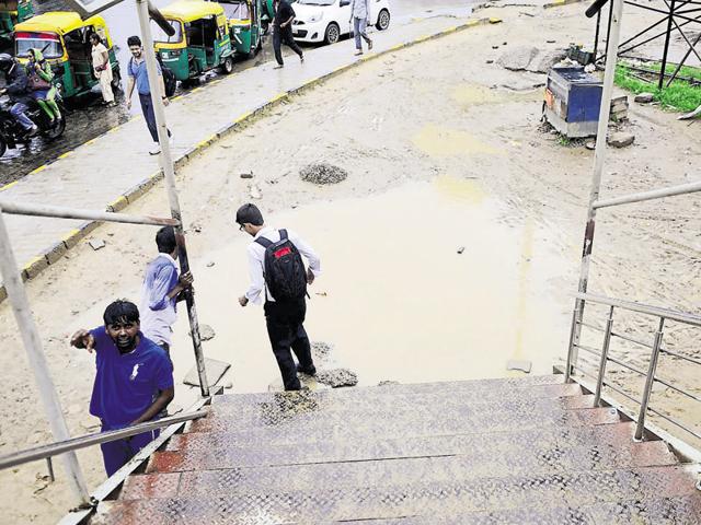 A commuter tries to hop over a puddle outside Huda City Centre metro station after the rain on Saturday. (Abhinav Saha/HT Photo) A commuter tries to hop over a puddle outside Huda City Centre metro station after the rain on Saturday. (Abhinav Saha/HT Photo)