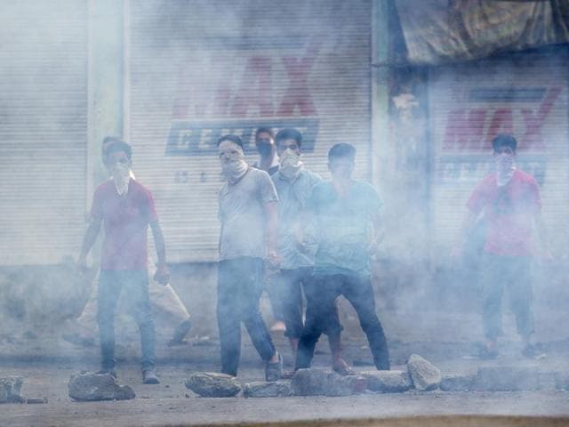 Masked protesters stands behind a screen of tear gas smoke in Srinagar, Kashmir. (AP Photo) Masked protesters stands behind a screen of tear gas smoke in Srinagar, Kashmir. (AP Photo)