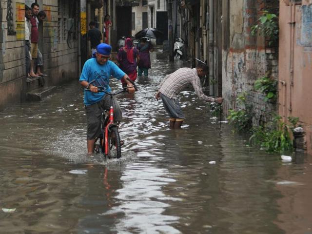 Water woes:  Residents of Krar Khan Mohalla trying to find a method  to the monsoon madness.  (Pardeep Pandit/HT Photo) 