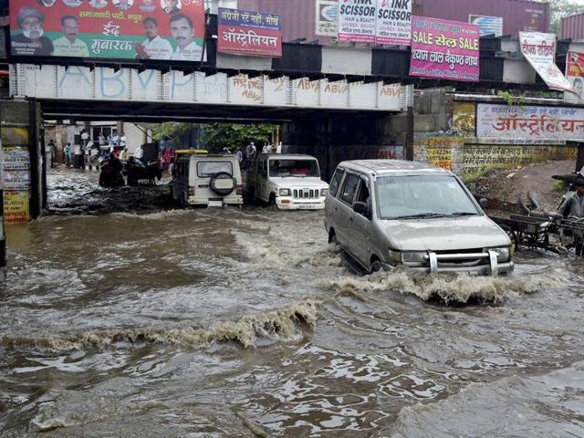 Traffic moves at a snail’s pace through a flooded street after heavy rainfall in Mathura on Saturday. (PTI) Traffic moves at a snail’s pace through a flooded street after heavy rainfall in Mathura on Saturday. (PTI)