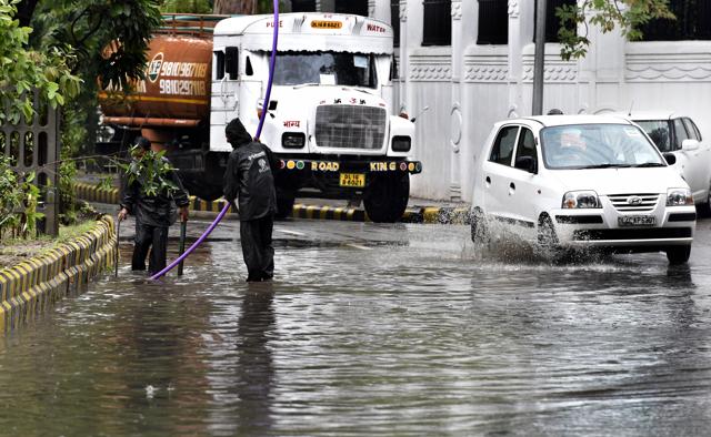 A civic worker tries to fix the drainage system on a road stretch near Jantar Mantar in the waterlogged Delhi. (Mohd Zakir/ HT Photo) A civic worker tries to fix the drainage system on a road stretch near Jantar Mantar in the waterlogged Delhi. (Mohd Zakir/ HT Photo)
