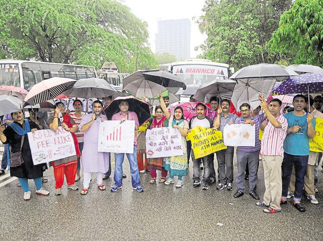 Unmindful of the downpour, parents protested against the fee hike outside Apeejay School in Sector 16A on Saturday. (Burhaan Kinu/HT Photo) Unmindful of the downpour, parents protested against the fee hike outside Apeejay School in Sector 16A on Saturday. (Burhaan Kinu/HT Photo)