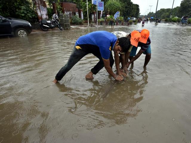 Workers try to fix the drainage system on a road stretch in the waterlogged Delhi. (Raj K Raj/ HT Photo) Workers try to fix the drainage system on a road stretch in the waterlogged Delhi. (Raj K Raj/ HT Photo)
