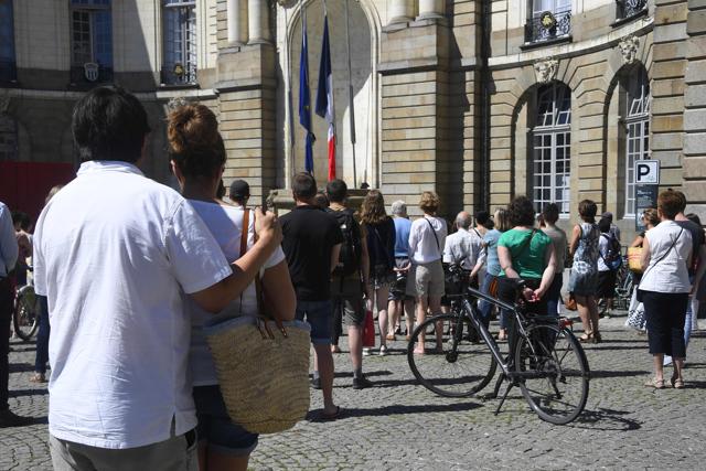 People look at flags lowered at half-mast as they observe a minute‘s silence in Rennes, western France, on Monday in tribute to victims of the Nice attack on Bastille Day. France held a minute's silence to honour the 84 victims of the attack but the period of national mourning was overshadowed by bickering politicians. (AFP)