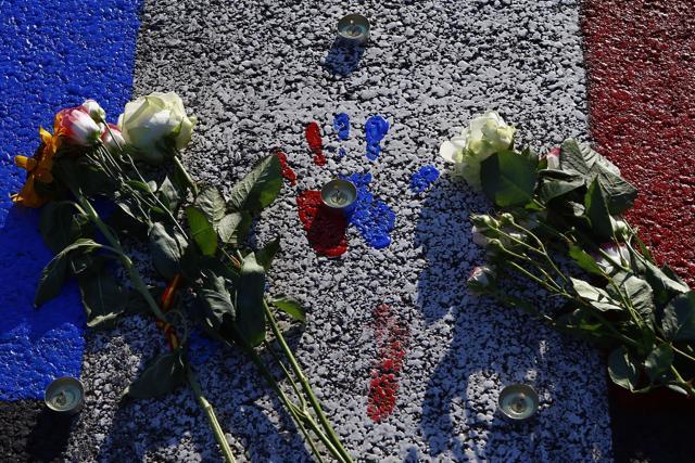 A painting with the colours of the French flag covers the asphalt near a makeshift memorial to honour the victims. (AP Photo) A painting with the colours of the French flag covers the asphalt near a makeshift memorial to honour the victims. (AP Photo)