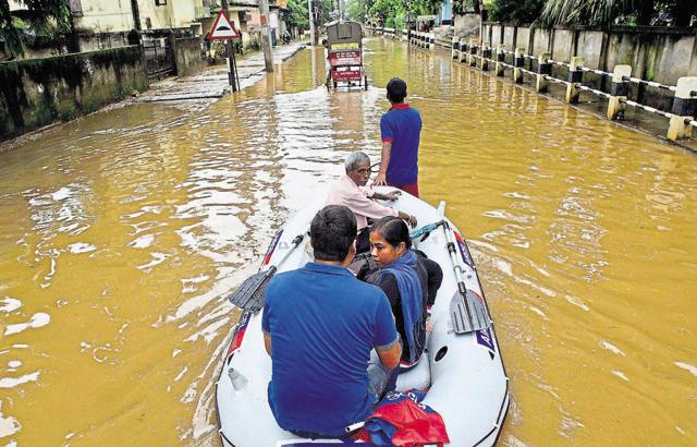 Volunteers shift people to higher areas after heavy monsoon rains flooded parts of Guwahati, Assam on Sunday. (AP)