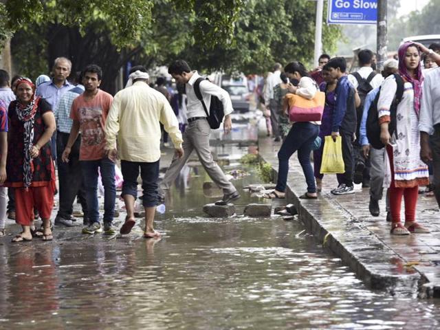 People wade through a water logged street near AIIMS. (Saumya Khandelwal/HT Photo) People wade through a water logged street near AIIMS. (Saumya Khandelwal/HT Photo)
