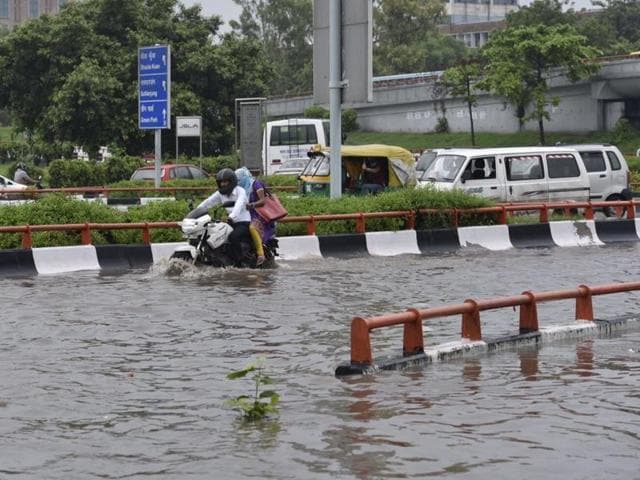 Commuters navigate through a water logged road near AIIMS. (Saumya Khandelwal/HT Photo) Commuters navigate through a water logged road near AIIMS. (Saumya Khandelwal/HT Photo)