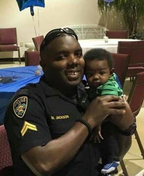 Baton Rouge police officer Montrell Jackson holds his son Mason at a Father's Day event for police officers in Baton Rouge. (AP Photo)
