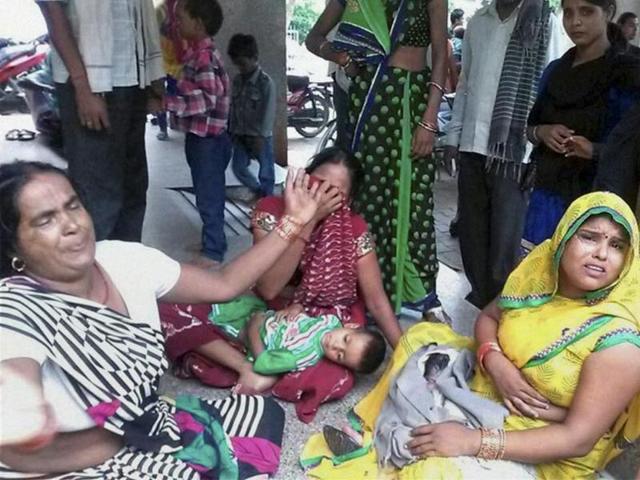 Relatives grieve after several people died due to consumption of spurious liquor in Farukhabad.(PTI Photo)