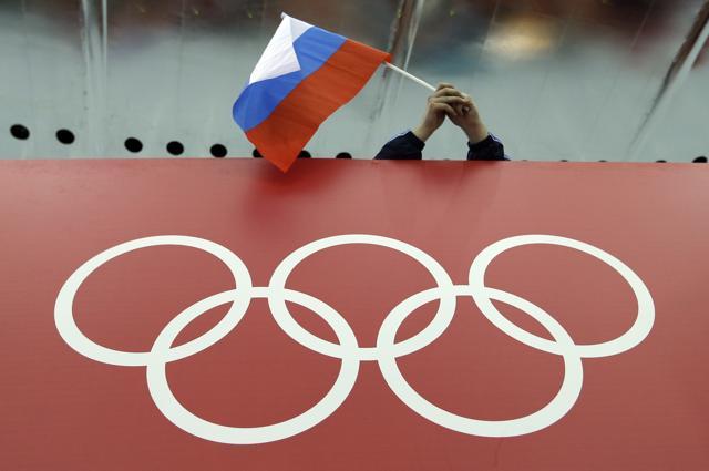 A Russian fan holds the country's national flag over the Olympic rings. (AP Photo) A Russian fan holds the country's national flag over the Olympic rings. (AP Photo)