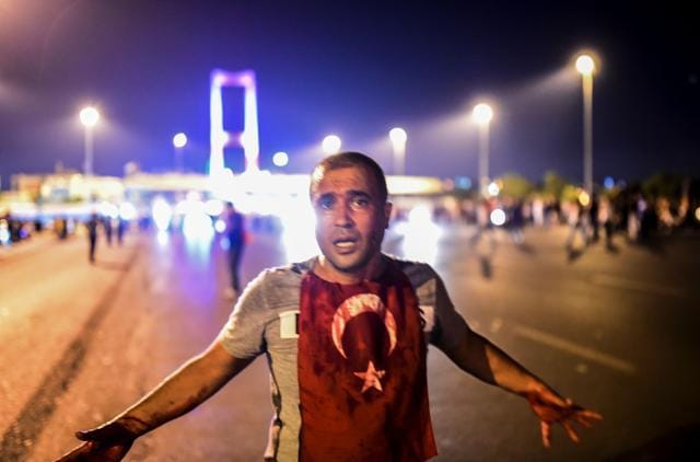 A man covered with blood stands near the Bosphorus bridge as Turkish military clash with people at the entrance to the bridge in Istanbul on July 16, 2016. (Bulent Kilic / AFP)
