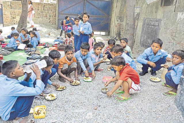 Kids crouching on the floor while having a mid-day meal at the elementary school in Mokampura near Amritsar. (Sameer Sehgal/HT Photo) Kids crouching on the floor while having a mid-day meal at the elementary school in Mokampura near Amritsar. (Sameer Sehgal/HT Photo)