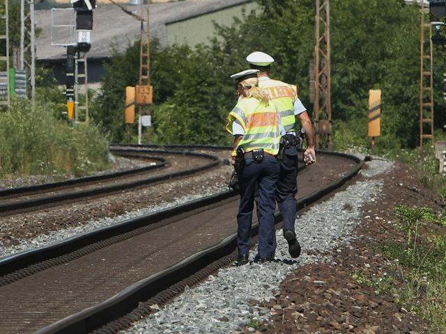 Police officers walk along train tracks in Wuerzburg southern Germany a day after a man attacked train passengers with an axe. (AFP Photo) Police officers walk along train tracks in Wuerzburg southern Germany a day after a man attacked train passengers with an axe. (AFP Photo)