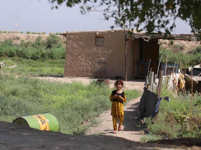 An Iraqi girl stands next to a hut. (AFP)