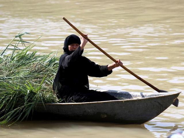 An Iraqi woman rides a boat. (AFP)