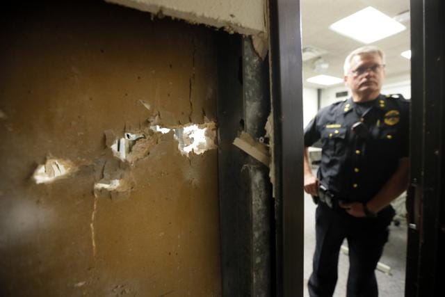 El Centro College Police chief Joseph Hannigan stands by a doorway with gun shot damage. (AP Photo)