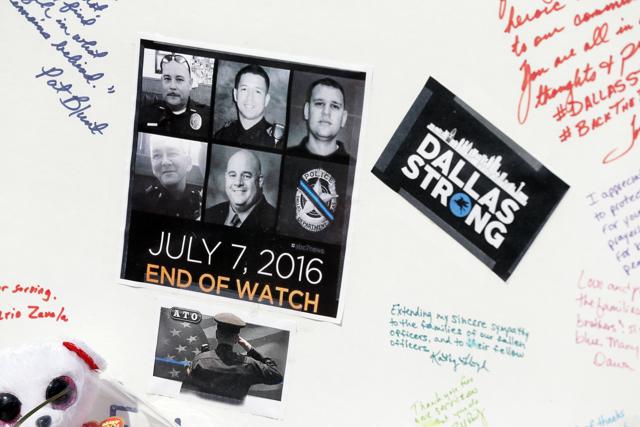 A photograph of the five police officers killed during a protest earlier this month in Dallas sits pasted onto a poster board with messages left at a makeshift memorial in front of the headquarters of the Dallas Police Department. (AP Photo)