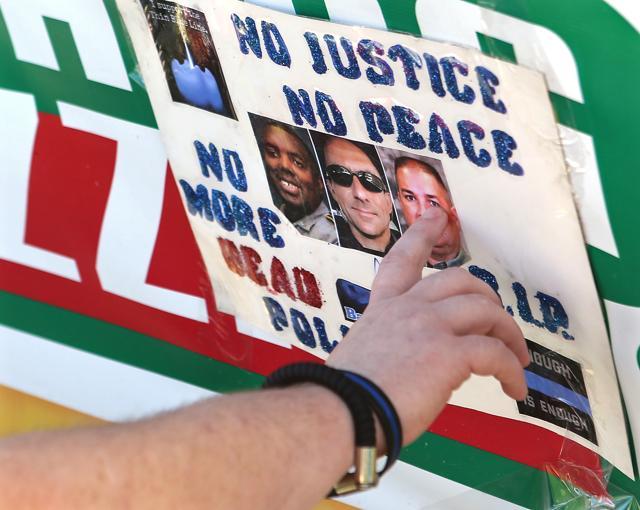 Matthew Ward, an employee with the Baton Rouge Sheriff's office who knew slain deputy Brad Garafola, touches his photograph while visiting a makeshift memorial for the officers who were killed and wounded in Sunday's shooting, at the B-Quik gas station on Tuesday, July 19, 2016, in Baton Rouge, La. (AP Photo) Matthew Ward, an employee with the Baton Rouge Sheriff's office who knew slain deputy Brad Garafola, touches his photograph while visiting a makeshift memorial for the officers who were killed and wounded in Sunday's shooting, at the B-Quik gas station on Tuesday, July 19, 2016, in Baton Rouge, La. (AP Photo)
