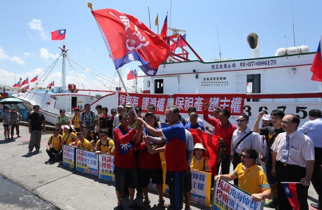 Taiwanese fishermen display flags and placards before departing to Taiping island. (AFP Photo)