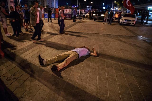 A injured man lies on ground after clashes at Taksim Square in Istanbul on July 16, 2016. (Ozan Kose / AFP)