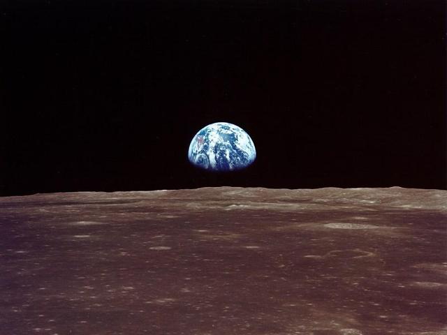 Just hours before landing on the moon, one of the astronauts snapped Earth’s rise as viewed from the lunar orbit.  (NASA) 