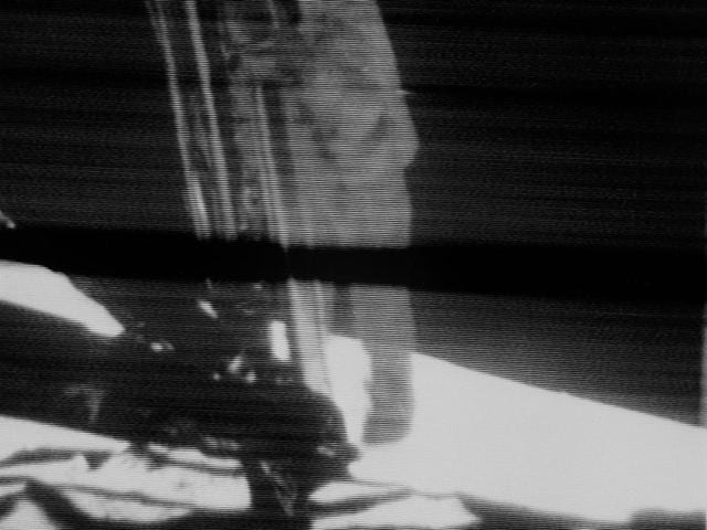 Apollo 11 commander Armstrong about to set foot on the moon. It was at this moment, standing on the ladder, he proclaimed “That’s one small step for a man, one giant leap for mankind.” The image is blurry as it is a screen grab from a camera that live-streamed the landing.  (NASA) 