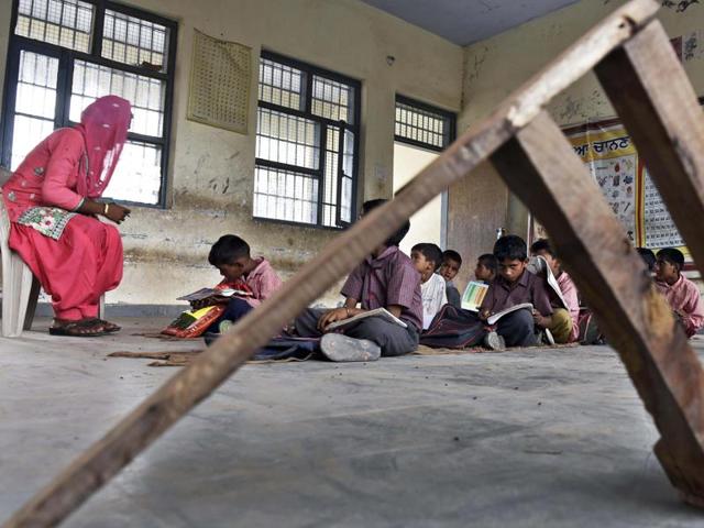 Children sitting on the floor in absence of furniture at the government elementary school in Bal Labe Darya village of Ajnala tehsil in Amritsar.(Gurpreet Singh/HT Photo)