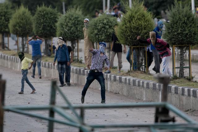 Masked Kashmiri protesters throw stones at soldiers and policemen in Srinagar. (AP Photo)