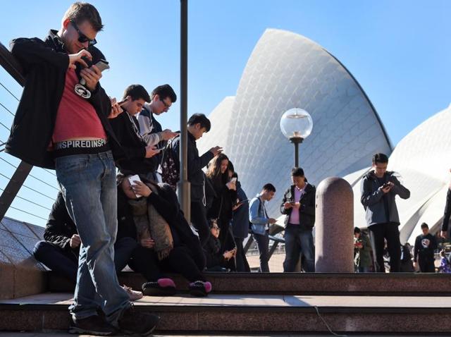 Dozens of people gather to play Pokemon Go in front of the Sydney Opera House on July 15, 2016.(AFP)