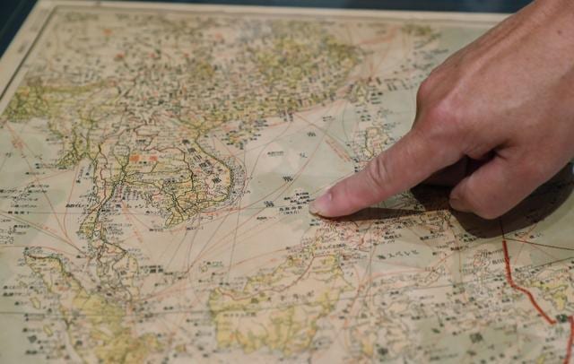 In this July 14 photo, Marcopolo Tam, a member of a pro-China business group in Hong Kong, points to what is now known as the Spratly Islands in the South China Sea on a Japanese World War II era map purporting to support China's claims to vast parts of the South China Sea, in Hong Kong. (AP) In this July 14 photo, Marcopolo Tam, a member of a pro-China business group in Hong Kong, points to what is now known as the Spratly Islands in the South China Sea on a Japanese World War II era map purporting to support China's claims to vast parts of the South China Sea, in Hong Kong. (AP)