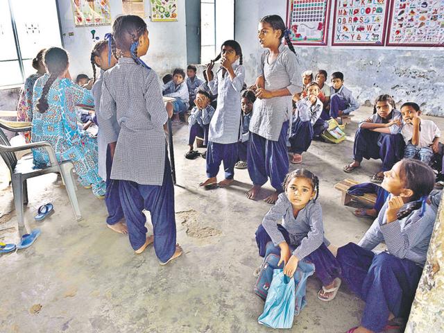 Students of Government Elementary School at Chakbala village in Amritsar district sitting on the floor due to lack of furniture.(Gurpreet Singh/HT Photo)