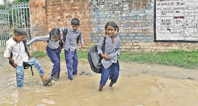 Students passing from waterlogged path in front of the main gate after school hours. (Gurpreet Singh/HT) Students passing from waterlogged path in front of the main gate after school hours. (Gurpreet Singh/HT)