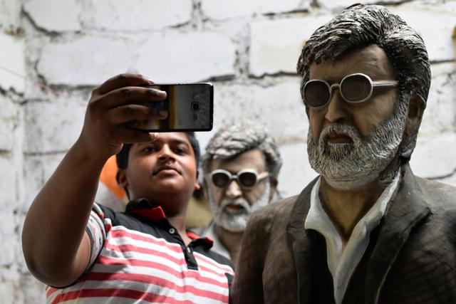A fan clicks a selfie alongside clay statues of Indian movie star Rajinikanth on the eve of the release of his latest movie 'Kabali', in Bangalore on Thursday. (AFP) A fan clicks a selfie alongside clay statues of Indian movie star Rajinikanth on the eve of the release of his latest movie 'Kabali', in Bangalore on Thursday. (AFP)