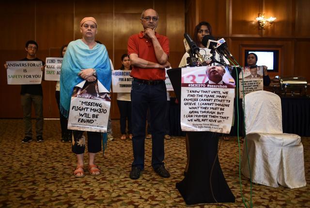 Relatives of passengers missing on Malaysia Airlines MH370 holds placards during a press conference after a meeting with the Joint Agency Coordination Centre and Australian Transport Safety Bureau at a hotel in Kuala Lumpur on Thursday. Transport ministers from Australia, China and Malaysia met on Friday to discuss the future of the frustrating deep-sea search for the missing flight. (AFP)