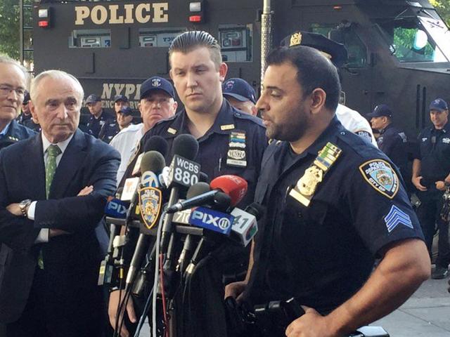In this photo provided by the New York Police Department (NYPD), Sgt. Hameed Armani, right, and Officer Peter Cybulski talk at a news conference, Thursday, July 21, 2016 at Columbus Circle in New York, about the hoax bomb that was tossed into their police van the night before in Times Square. (AP Photo) In this photo provided by the New York Police Department (NYPD), Sgt. Hameed Armani, right, and Officer Peter Cybulski talk at a news conference, Thursday, July 21, 2016 at Columbus Circle in New York, about the hoax bomb that was tossed into their police van the night before in Times Square. (AP Photo)