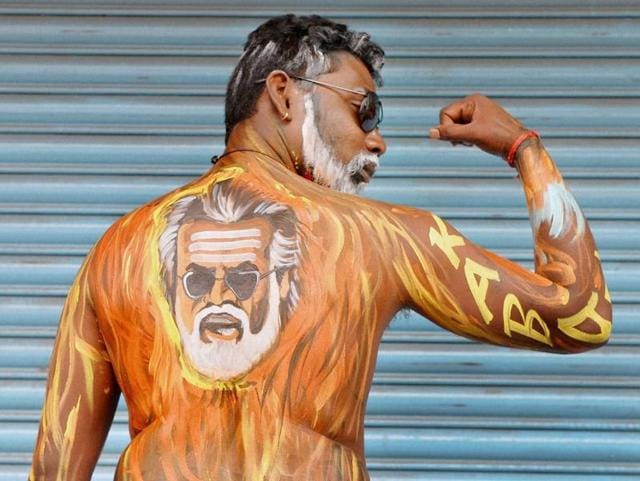 A fan in Bengaluru sports Rajinikanth's face painted on his body as the actor’s film Kabali hit the theatres today. (PTI)