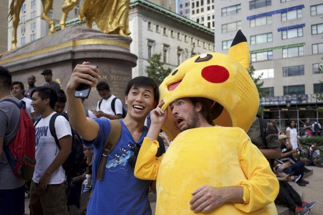 Tommy Zhang, left, a Pokemon Go trainer, in New York on July 19, 2016. For underemployed 20-somethings, training newbies in the finer points of Pokemon Go has emerged as a fresh career. (NYT)