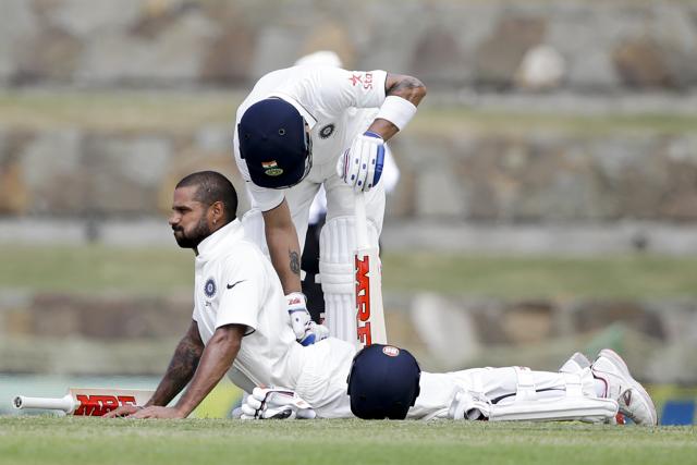 India captain Virat Kohli helps teammate Shikhar Dhawan stretch during the first Test match against West Indies at the Sir Vivian Richards Stadium in North Sound, Antigua, on Thursday. (AP Photo) India captain Virat Kohli helps teammate Shikhar Dhawan stretch during the first Test match against West Indies at the Sir Vivian Richards Stadium in North Sound, Antigua, on Thursday. (AP Photo)