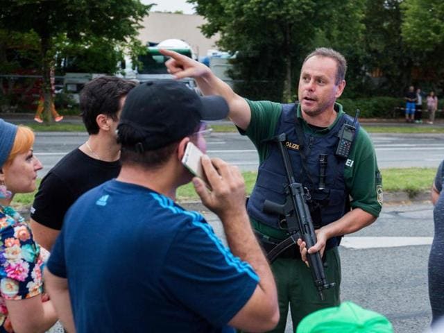A policeman explains teh situation near a shopping mall in Munich on July 22 following shootings. (AFP) A policeman explains teh situation near a shopping mall in Munich on July 22 following shootings. (AFP)