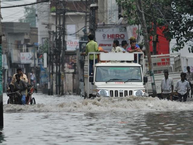 A jeep half immersed in water passing through a waterlogged road in Jalandhar. (Pardeep Pandit/HT Photo) 