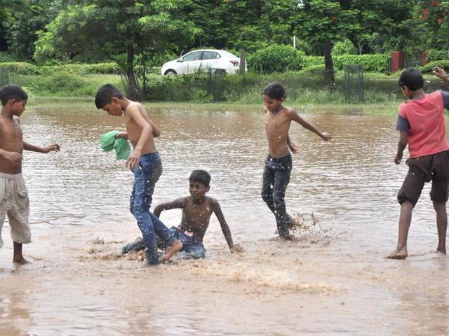 Children playing on a waterlogged street in Panchula on Saturday. (Sant Arora/HT Photo) Children playing on a waterlogged street in Panchula on Saturday. (Sant Arora/HT Photo)