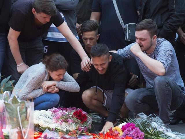 People mourn with flower tributes near the Olympia shopping centre where a shooting took place leaving nine people dead the day before in Munich, Germany. (AP Photo) People mourn with flower tributes near the Olympia shopping centre where a shooting took place leaving nine people dead the day before in Munich, Germany. (AP Photo)