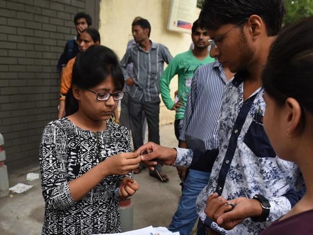 A girl removes her jewellery and other accessories before entering the examination hall at Kerala School in New Delhi on Sunday. (Sushil Kumar/ Hindustan Times)