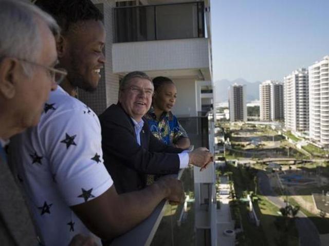 IOC president Thomas Bach (centre) talks with refugees and judo athletes from the Democratic Republic of Congo Yolande Mabika (right) and Popole Misenga as they visit an apartment at the Olympic Village in Rio de Janeiro, Brazil. (AP Photo)